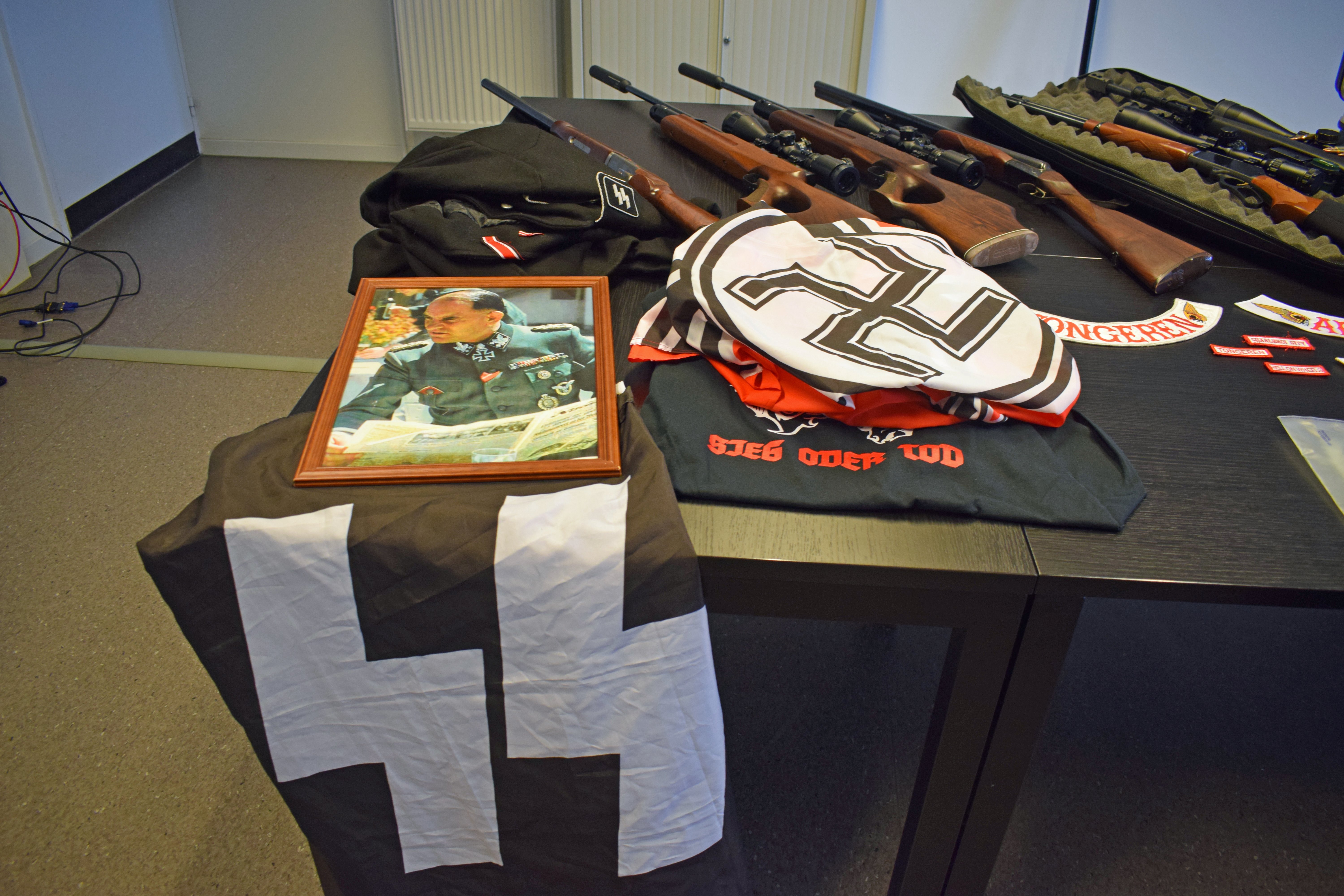 Beschlagnahmte Waren, darunter Nazi-Propaganda und Waffen, werden nach einer Razzia in Hasselt, Belgien, ausgestellt