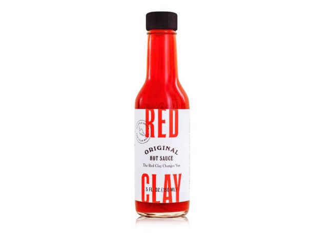 Flasche scharfe Red Clay-Sauce auf weißem Hintergrund