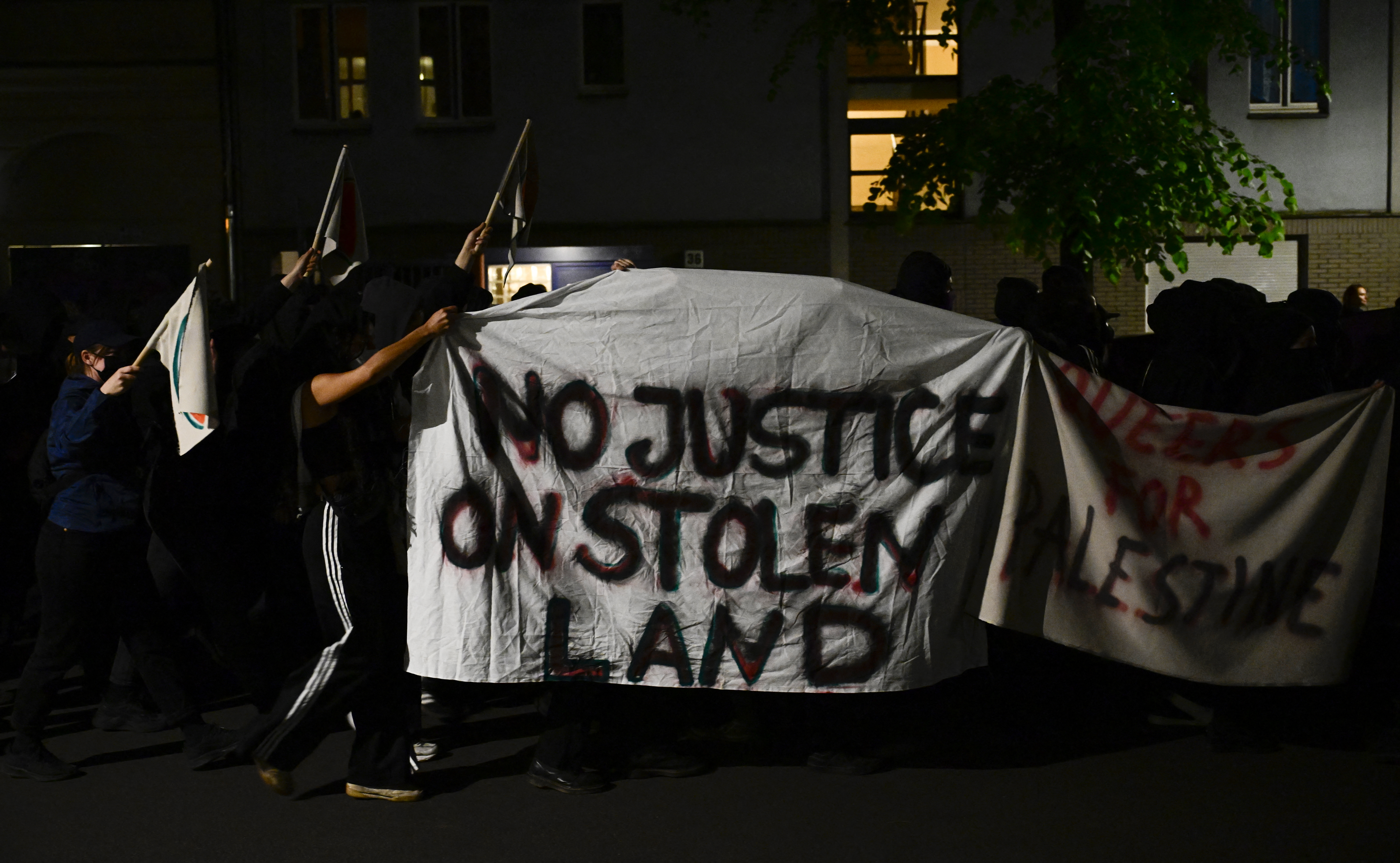Demonstranten halten Transparente mit der Aufschrift „Keine Gerechtigkeit auf gestohlenem Land“ und „Queers für Palästina“ hoch, während antiisraelische Demonstranten sich mit dem Schwarzen Block zusammenschließen