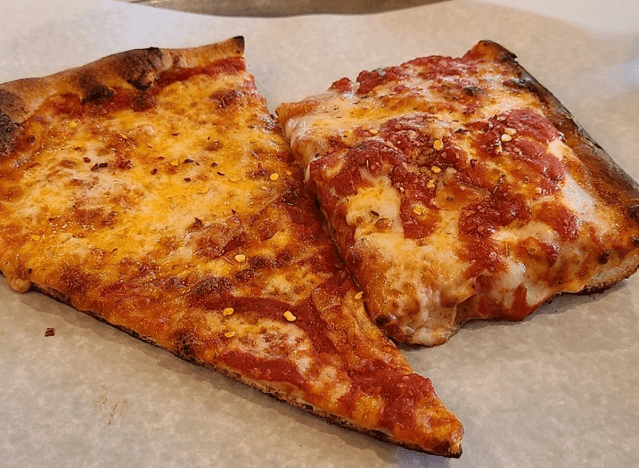 a slice of regular pizza next to a sicilian slice.