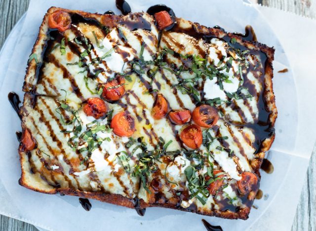 Pizza topped with chunky tomato sauce, burrata, and balsamic glaze at Providence Pizzeria