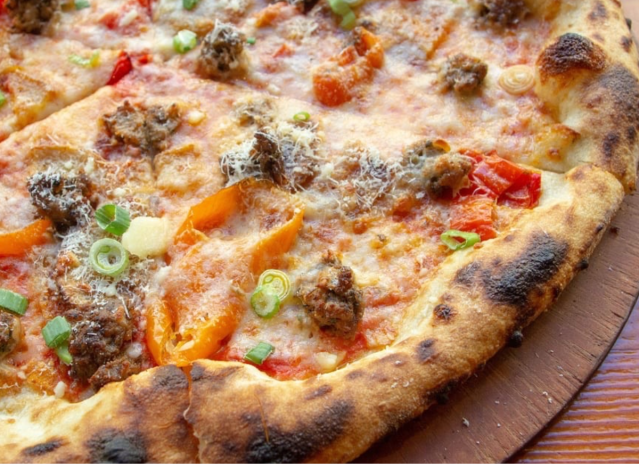 a pizza with sausage and colorful peppers.