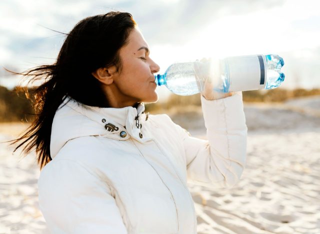 Frau trinkt Wasserflasche draußen
