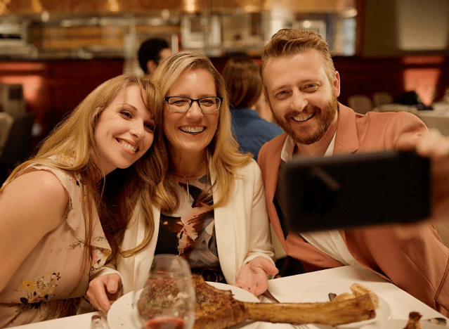 Drei Personen genießen ein Muttertagsessen bei Flemings und machen Selfies