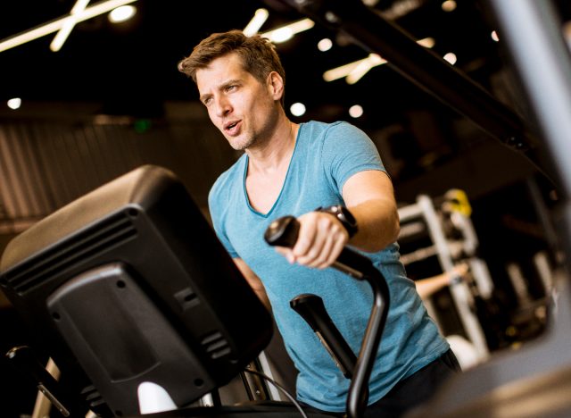 Fitter Mann auf Crosstrainer, Konzept von Cardio-Übungen, um auch im Alter fit zu bleiben