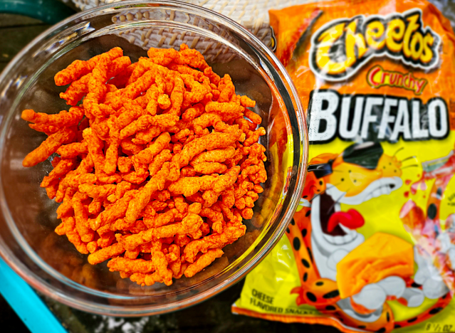 Knusprige Buffalo-Cheetos in einer Schüssel neben einer Tüte.