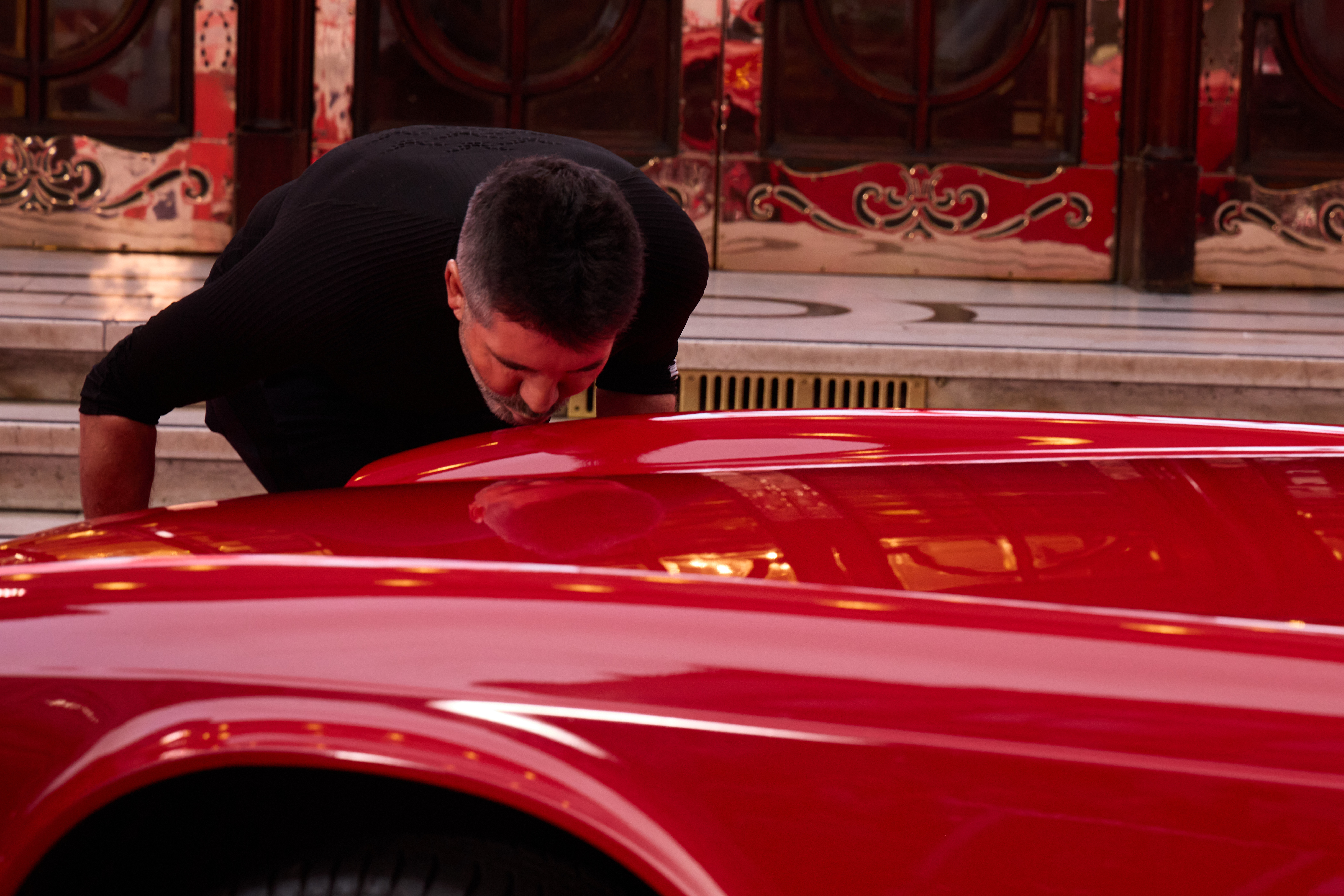 Simon wird vor dem Palladium wieder mit dem Auto vereint und ist so aufgedreht, dass er einen Klatscher auf die Motorhaube schlägt