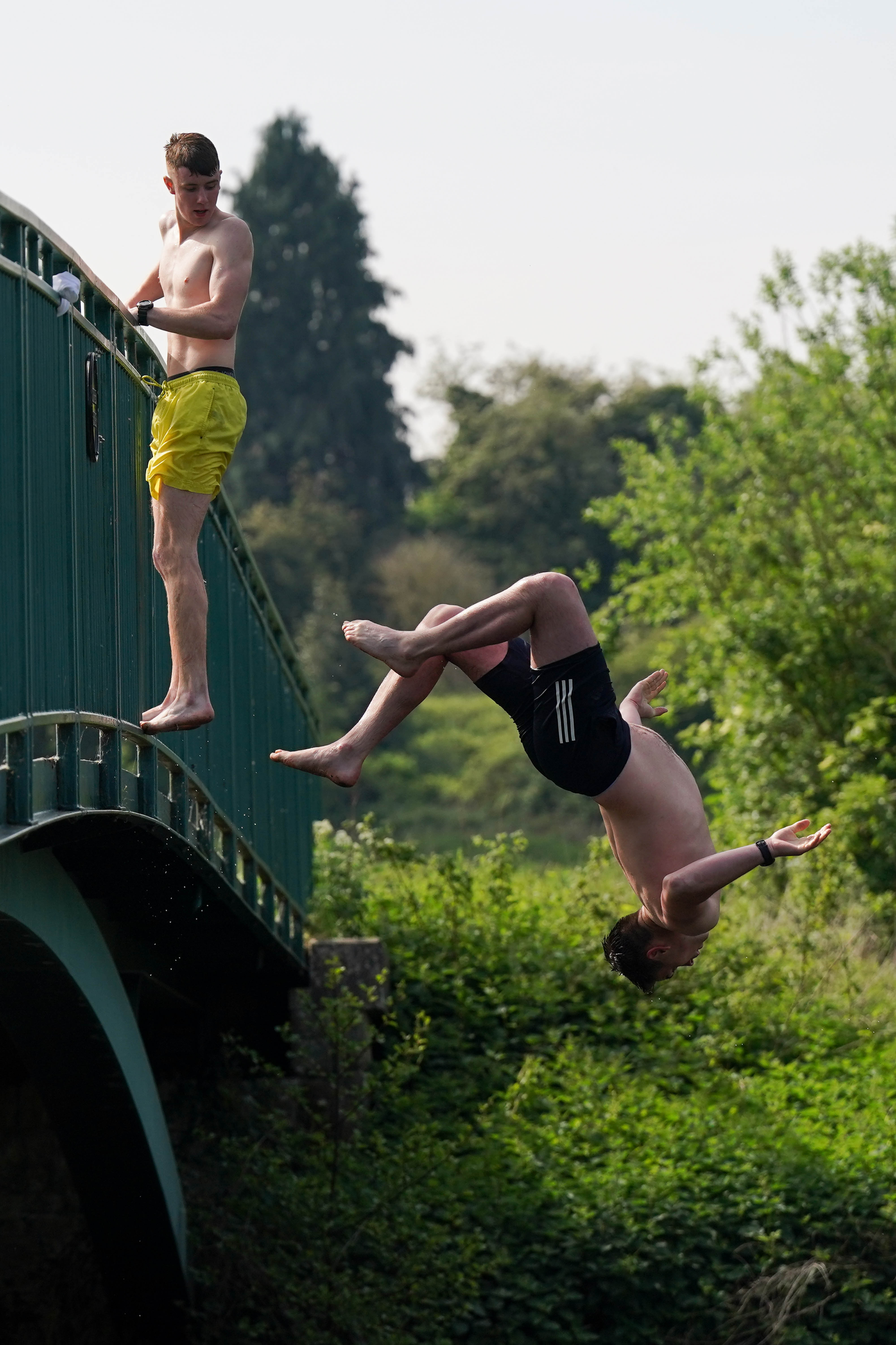 Freunde springen von einer Brücke im St. Nicholas' Park in Warwick in den Fluss Avon
