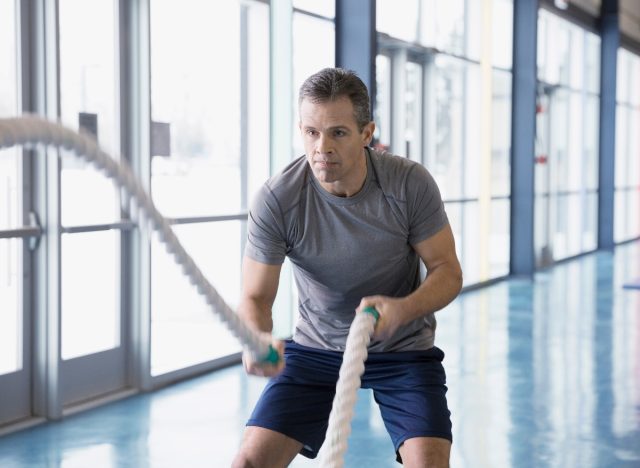 Mann mittleren Alters macht Kampfseil-Ausdauerübungen, um die Ausdauer zu verbessern