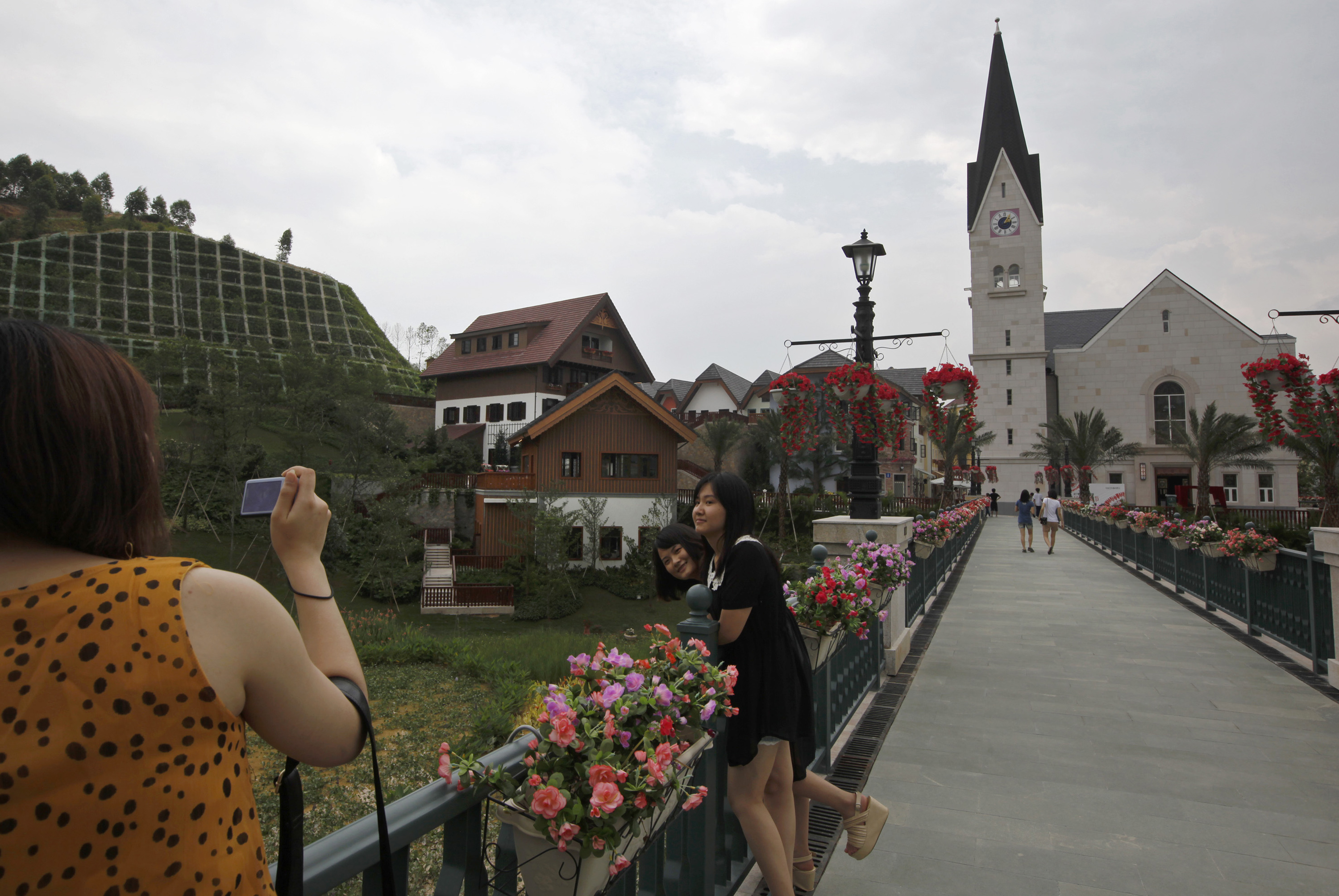 Chinesische Besucher machen Fotos von Häusern im europäischen Stil am Hallstätter See, einer Nachbildung der österreichischen Stadt Hallstatt in China im Jahr 2012.