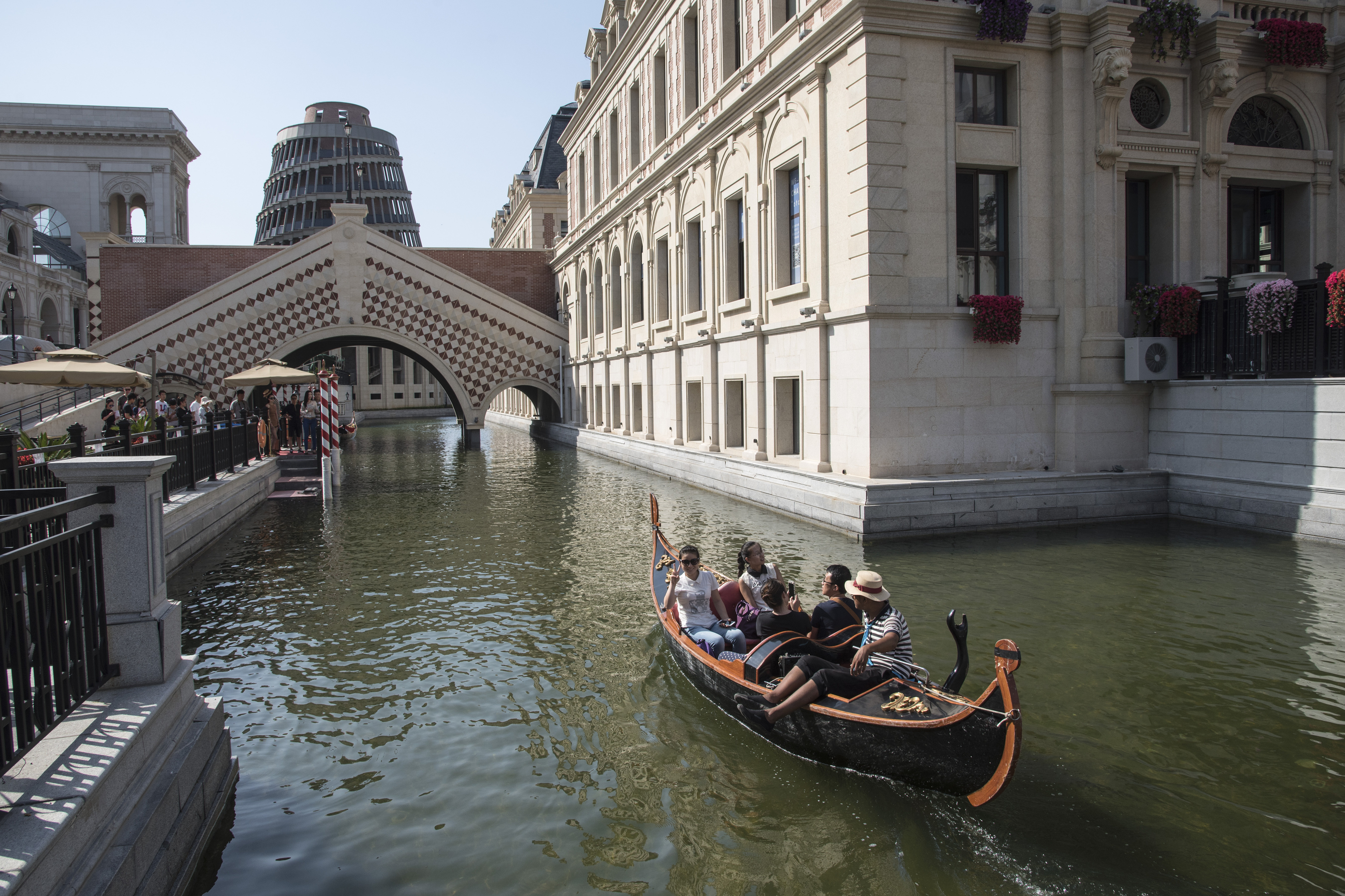 Touristen reisen 2015 in einer Gondel auf einem Kanal im chinesischen Fake-Venedig